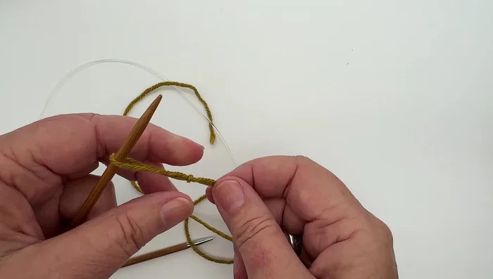 Insert needle tip through the slip knot and pull the working yarn (attached to the ball) to close the slip knot.