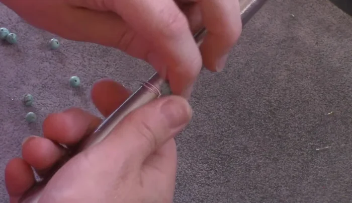 Continue wrapping until the wire is used up, maintaining consistent spacing between beads and keeping the wires close to the ring's base.