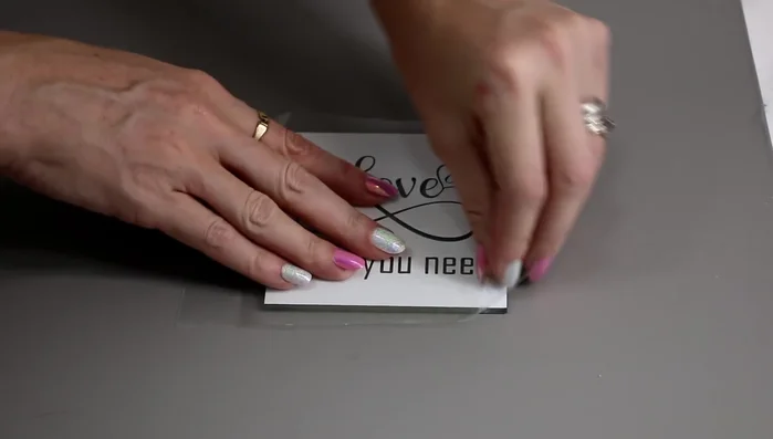 Roll over the stencil with a scraper to ensure it is firmly adhered and has no air bubbles.