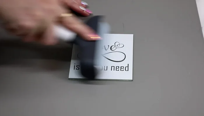 Roll over the stencil with a scraper to ensure it is firmly adhered and has no air bubbles.