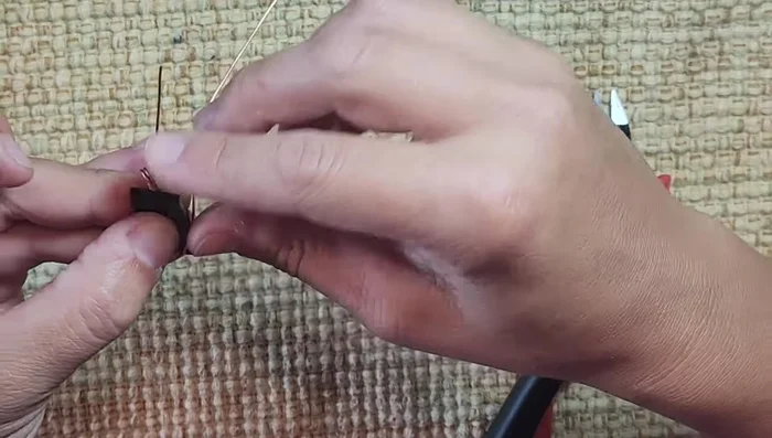 Wrap the wire around the stone, anchoring it at the bottom corner, then around the back, keeping the bale centered and tight. Bring the wire back to the front, around the back again, and anchor it at the top corner.