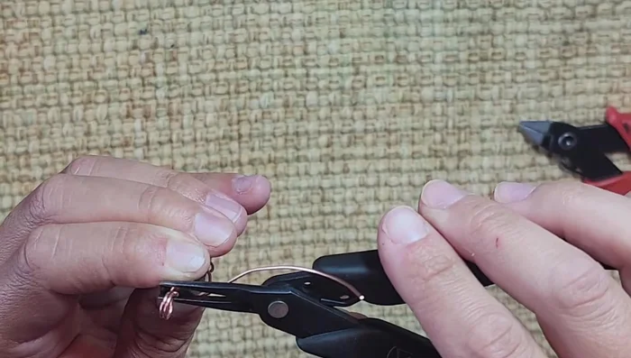 Pinch the cut wire ends with pliers to secure and prevent sharp edges.