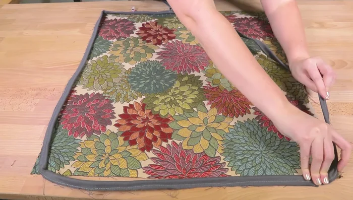 Sew the piping to the body pieces of the cushion, leaving space to avoid showing the seam.