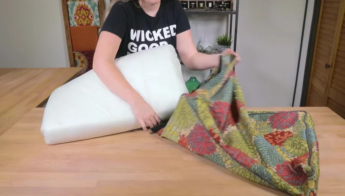 Turn the cushion right-side out, stuff the foam inside, and ensure the padding is flat and corners are properly pushed out.