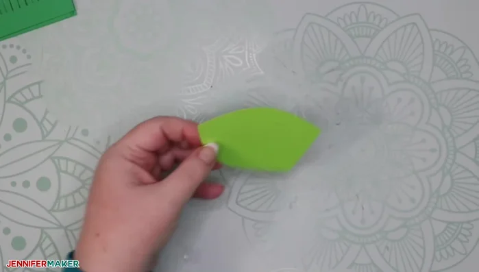 Fold about half of each color of leaves in half and glue them to the outer edge of the wreath form, maintaining uniform spacing (about 1.5-inch gaps).