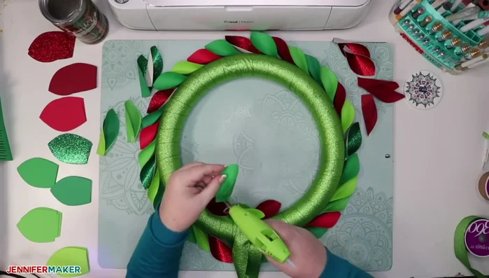 Glue the remaining leaves to the inner edge of the wreath form, alternating between parallel and angled upward positioning.