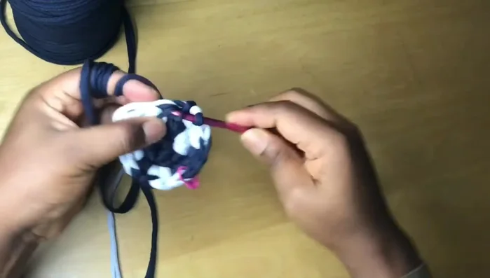 Continue the pattern of one single crochet in most stitches, two in the last stitch of each color section, changing colors as desired to create the spiral effect.