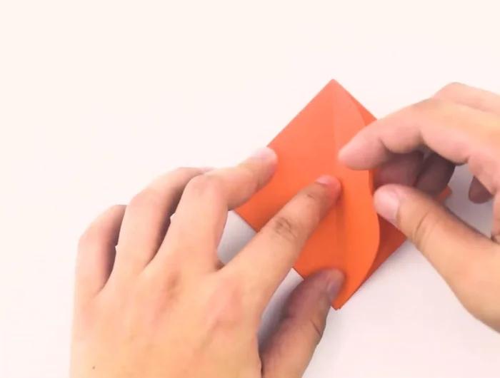 Fold the top of the diamond down, aligning the crease with the horizontal line created by the previous triangles. Then unfold to return to the small diamond shape.