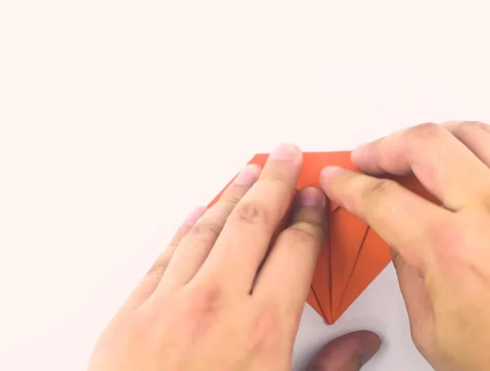 Fold the top of the diamond down, aligning the crease with the horizontal line created by the previous triangles. Then unfold to return to the small diamond shape.