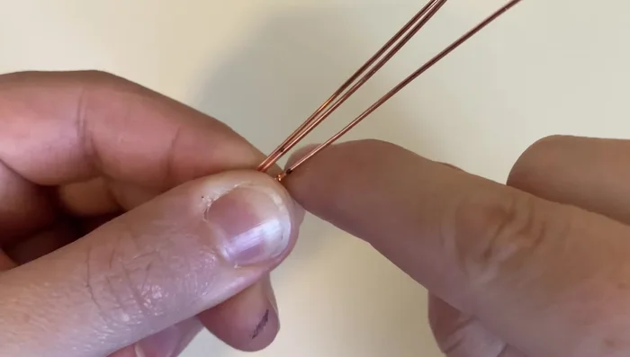 Compress the weave and wrap the weaving wire around the bottom base wire three more times to secure it. Trim excess wire.