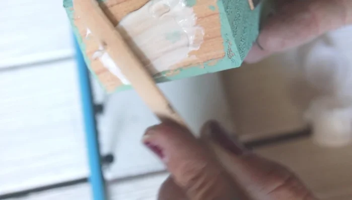 Glue the house to the base: Apply wood glue to the bottom base and secure the house.