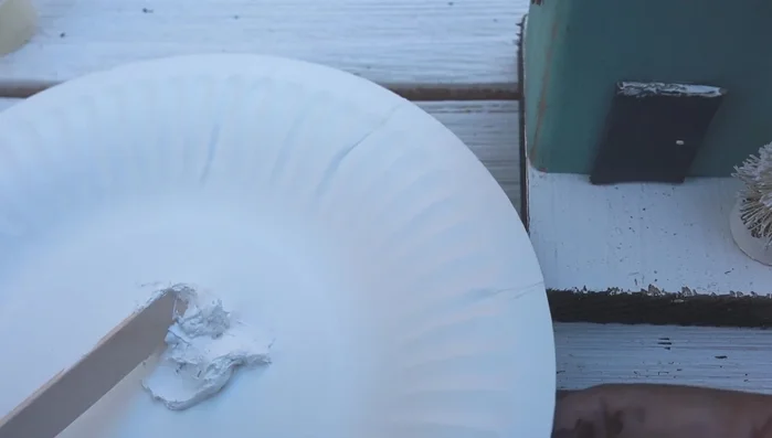 Apply snow: Apply the snow to the roof, base, door, and tree using a toothpick to create texture.