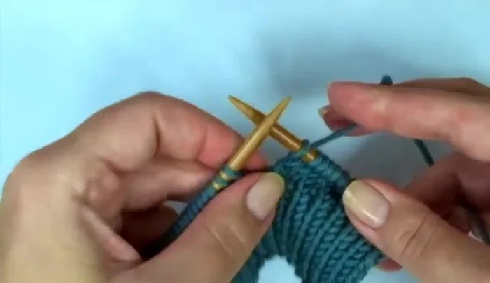 Shape the thumb: Knit 13 stitches, increase (right-leaning increase), knit following stitch, increase (left-leaning increase), knit to end of row. Repeat increases every other row.