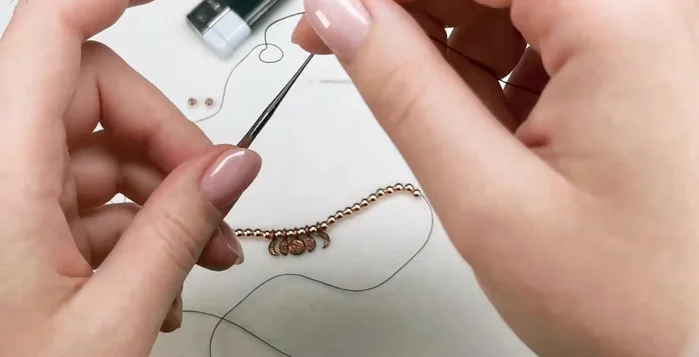 Create the initial slip knot: Thread the cord behind and then above the crochet hook to create a loop. Pass the end of the thread through the loop to secure the slip knot.