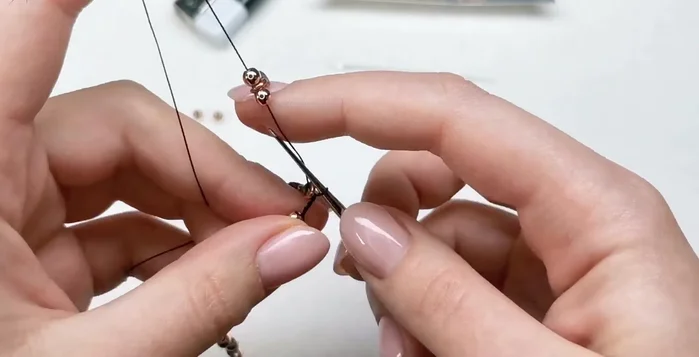 Add charms: Add charms by creating a larger loop and threading the cord through the loop, creating three chain stitches after each charm.