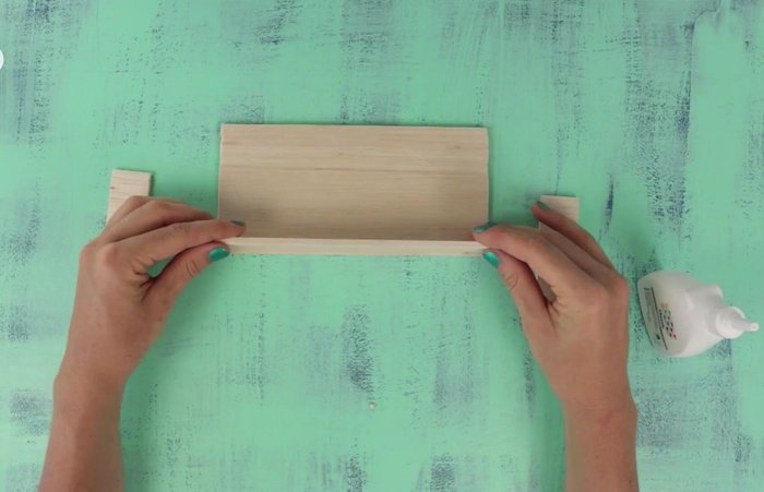 Glue balsa wood sheets together to form a pouch.