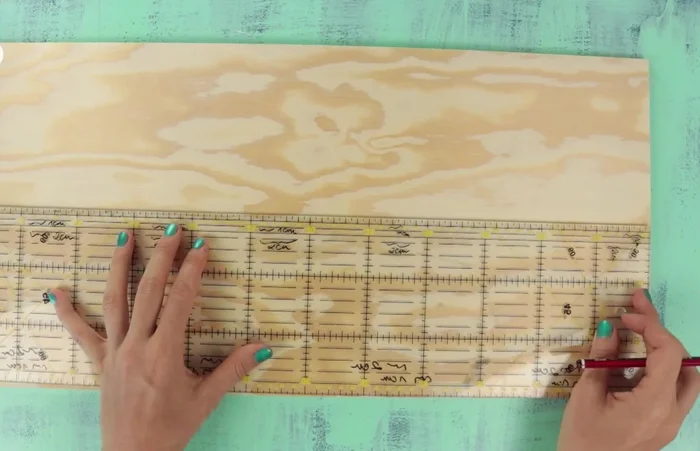 Position the cork, notebook pouch, and decorative elements on the wooden board. Mark the center and ensure proper spacing.