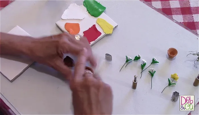 Prepare the flower pot: Place brown clay into the pot, pressing it down as if it were dirt. Add Spanish moss for added texture (optional).