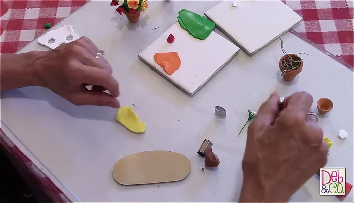 Create daffodil flowers: Use two sizes of leaf cutters (smaller for outer petals, yellow clay) to create five outer petals and three inner petals. Connect the petals, ensuring the pointed side faces outwards. Add a yellow center using larger leaf-shaped pieces.