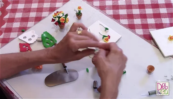 Assemble the arrangement: Arrange the cooled flowers and leaves in the prepared flower pot.