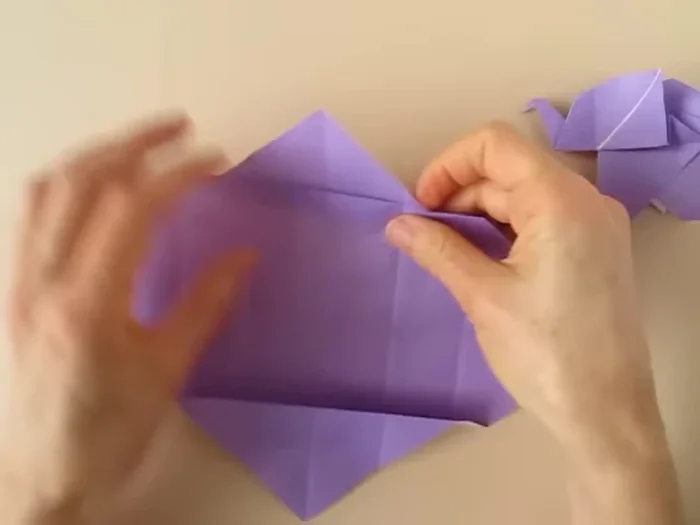 Fold along the center so that the central fold is a mountain fold. Rotate so that the point is up, fold and collapse.