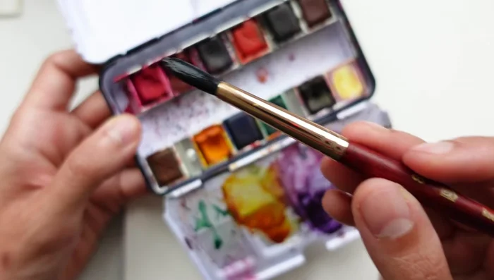 Rinse most of the pigment from your size 8 brush, keeping it wet. Use the brush tip to drag out pigment and lay down pressure to create petals. Repeat this process around the center, using about five or six petals.