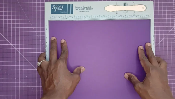 Perform the unique John B. Crops-inspired fold to create clean edges. Fold the paper in half, then bring the scored edges together to create a precise, clean crease.
