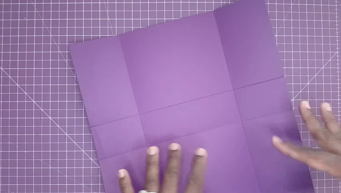 Perform the unique John B. Crops-inspired fold to create clean edges. Fold the paper in half, then bring the scored edges together to create a precise, clean crease.