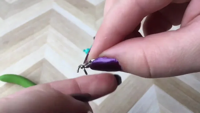 Attach the charm to the jump ring by inserting the charm's bail (or loop) into the open jump ring.