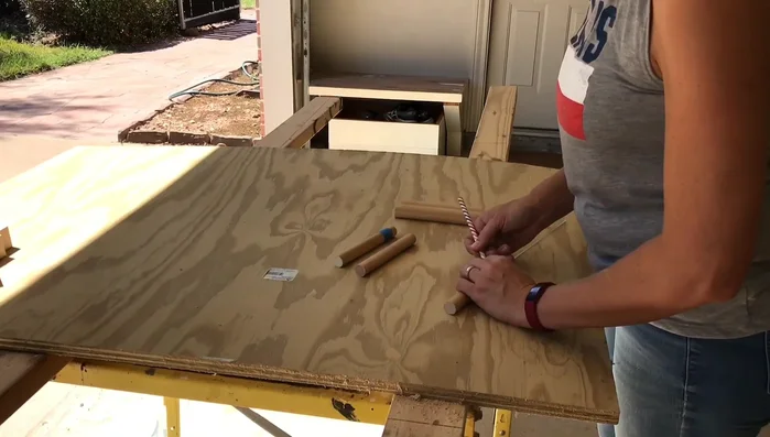 Mark three-quarter inches up on each side of the dowels with painter's tape for gluing.