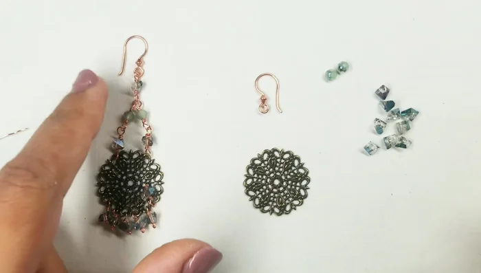 Fold the wire over the prong of the bead, flip it over, and wrap it around the smaller prong. Wrap three times and cut off the excess wire.