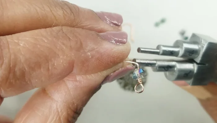 Fold the wire over the prong of the bead, flip it over, and wrap it around the smaller prong. Wrap three times and cut off the excess wire.