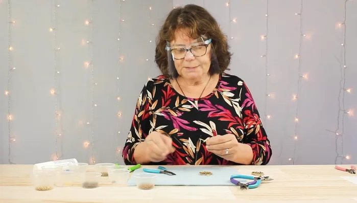 Create the beaded link: Straighten an eye pin and add beads to it. Form a loop at the end using round nose pliers.