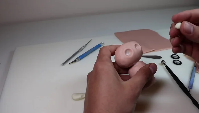 Create eye sockets in the owl's head using a ball stylus and fill with glow-in-the-dark clay. Add irises with black Sculpey Primo clay.