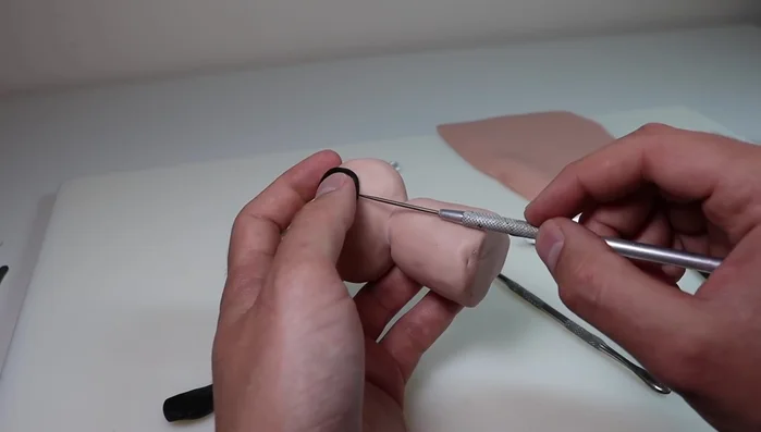 Attach the pre-baked goggles: Create a rim around each eye socket with clay. Make a small hole in an inconspicuous area of each goggle to release air during baking. Secure lenses with Bacon Bond.