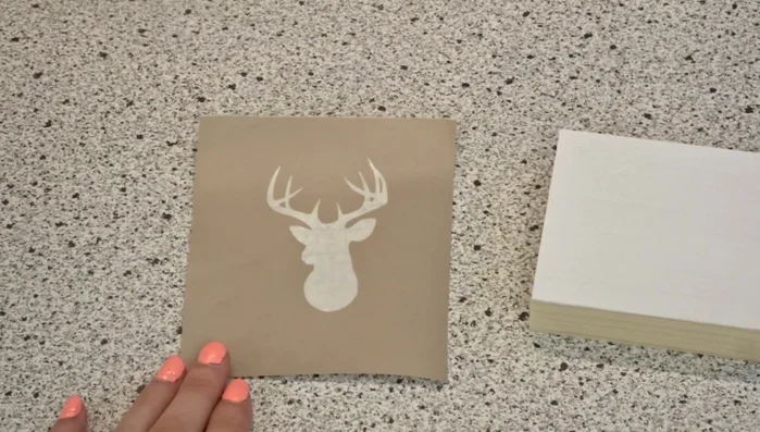 Carefully adhere the stencil to the wood. Press firmly from the center outwards, ensuring no air bubbles are trapped. 