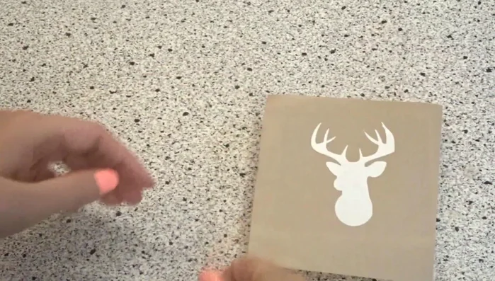 Carefully adhere the stencil to the wood. Press firmly from the center outwards, ensuring no air bubbles are trapped. 