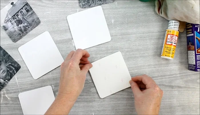 Transfer the image. Press the adhesive-backed picture onto the painted coaster, applying firm pressure with a stir stick in both vertical and horizontal directions to ensure good adhesion. Wet the paper backing with a damp rag, pressing gently to release the paper and leave the image on the coaster. This may require multiple wettings and pressings.