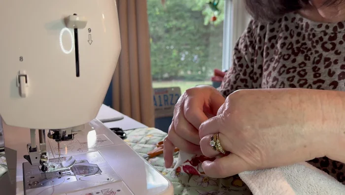 Sew the pot holder onto the towel along its edge, using a backstitch for security.