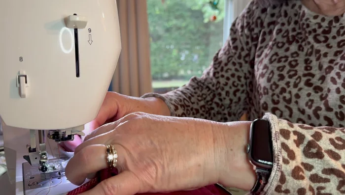 Sew the pot holder onto the towel along its edge, using a backstitch for security.