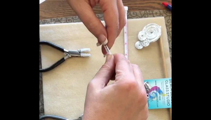 Continue rolling and flattening the wires, creating a swirl pattern. Keep pulling on both sides to maintain a flat shape.