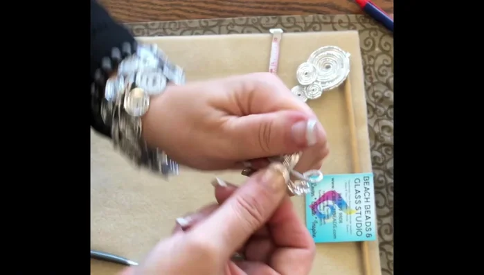 Continue rolling and flattening the wires, creating a swirl pattern. Keep pulling on both sides to maintain a flat shape.