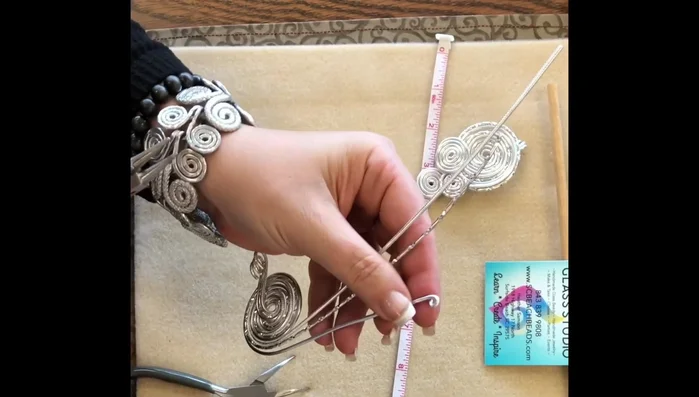 Arrange the loops to create the desired three-swirl pattern. The placement can be adjusted.