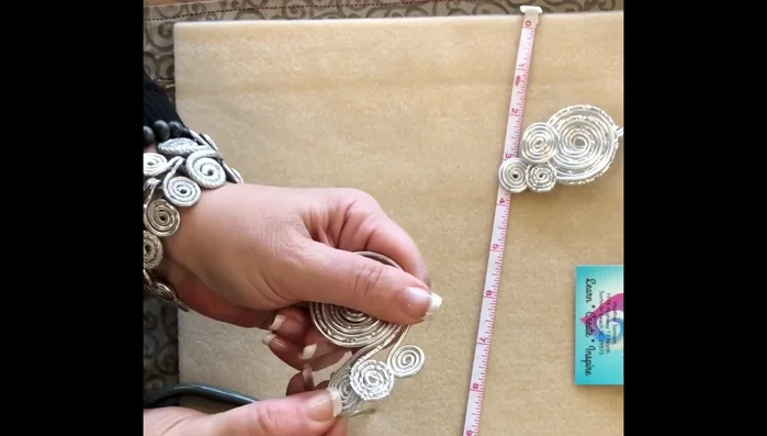 Arrange the loops to create the desired three-swirl pattern. The placement can be adjusted.