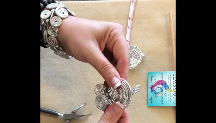 Cut 36 inches of 3mm rat tail and thread it through the loops of the pendant. Tie a knot and cinch it down to secure the pendant.