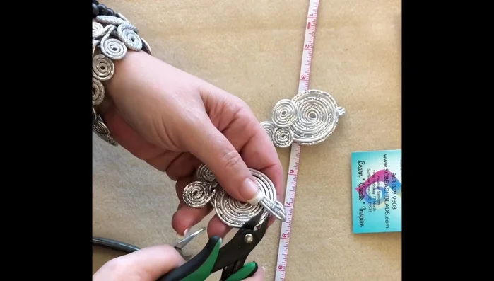 Cut 36 inches of 3mm rat tail and thread it through the loops of the pendant. Tie a knot and cinch it down to secure the pendant.