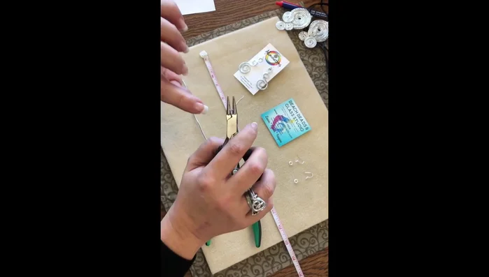 Using round nose pliers, create a 'J' shape at one end of each wire, then continue turning to create the first swirl. Keep the pliers close to the working area to target the swirl and avoid unnecessary movement.