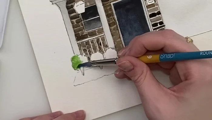 Painting the lawn with a soft green wash, blending edges for a natural look.