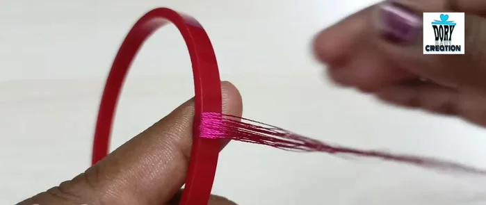 Clean and flatten: While the glue is still wet, carefully smooth and flatten the threads to eliminate any bumps, ridges, or overlaps. Use your thumb to press firmly and ensure even coverage.