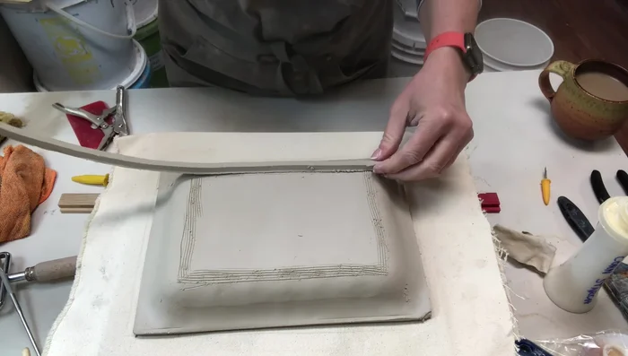 Smoothing out any gaps or tool marks with a wooden tool and a paint brush.